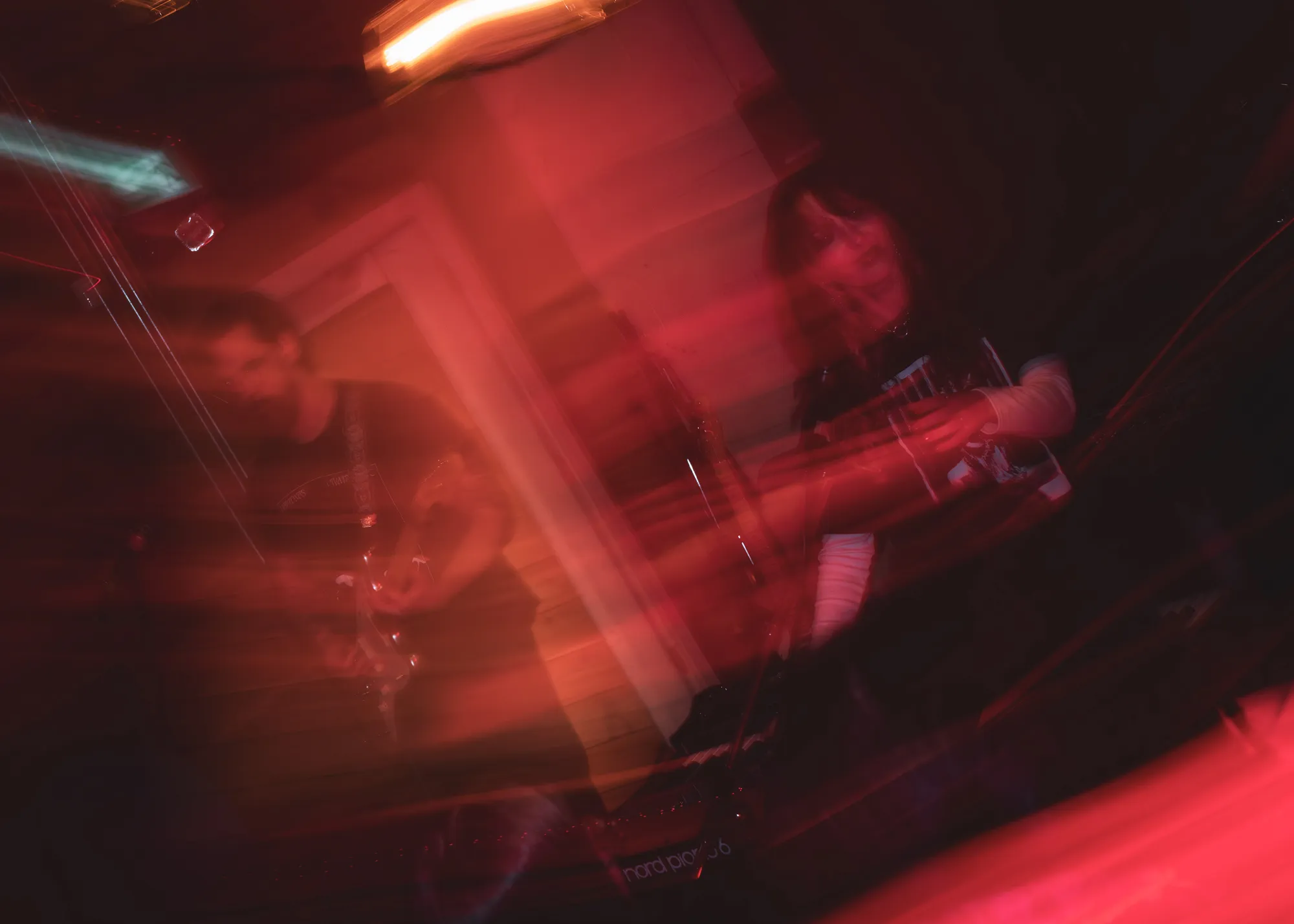 Guitarist smeared in blood-red long exposure blur
