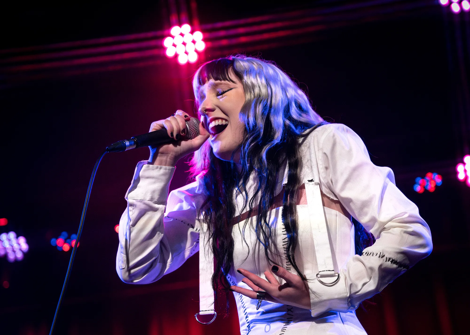 FKA Rayne in a cluster of orchid-toned stage lights at the Wise Hall, 2026. Live photo by Spencer Nakamura.