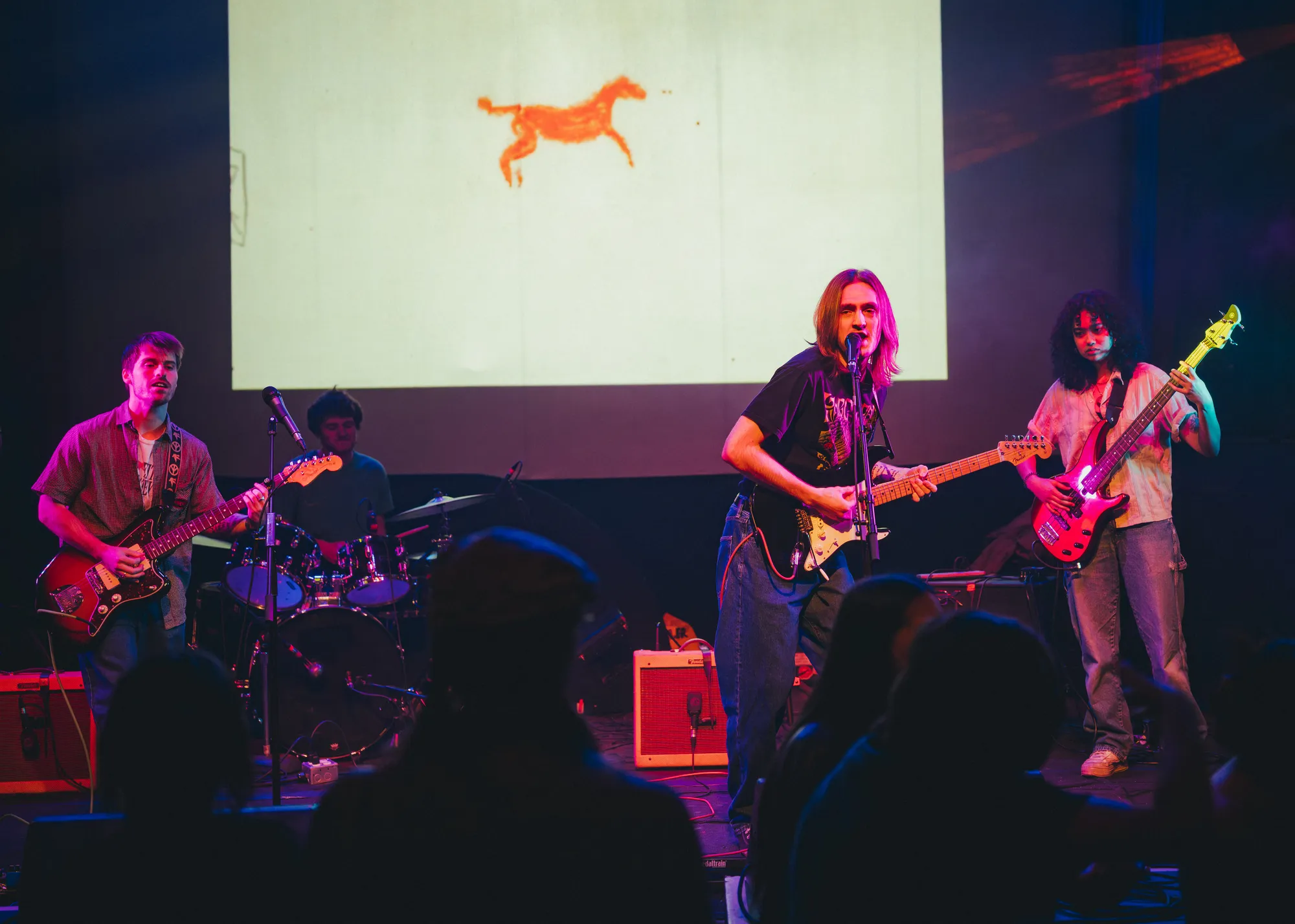 Full band mid-song beneath a projected orange horse at the Fox Cabaret